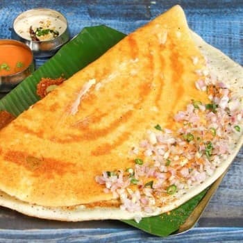 Crisp onion dosa topped with onions
